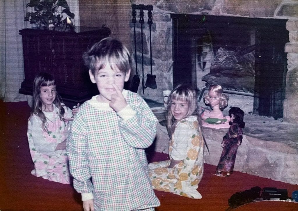Un grup de copii în pijamale stând în fața unui șemineu.